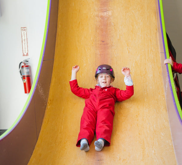 4 kids climbing a rock wall