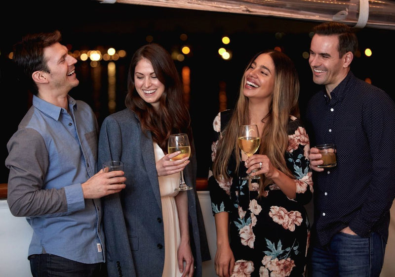 friends-laughing-and-having-drinks-on-a-dinner-cruise