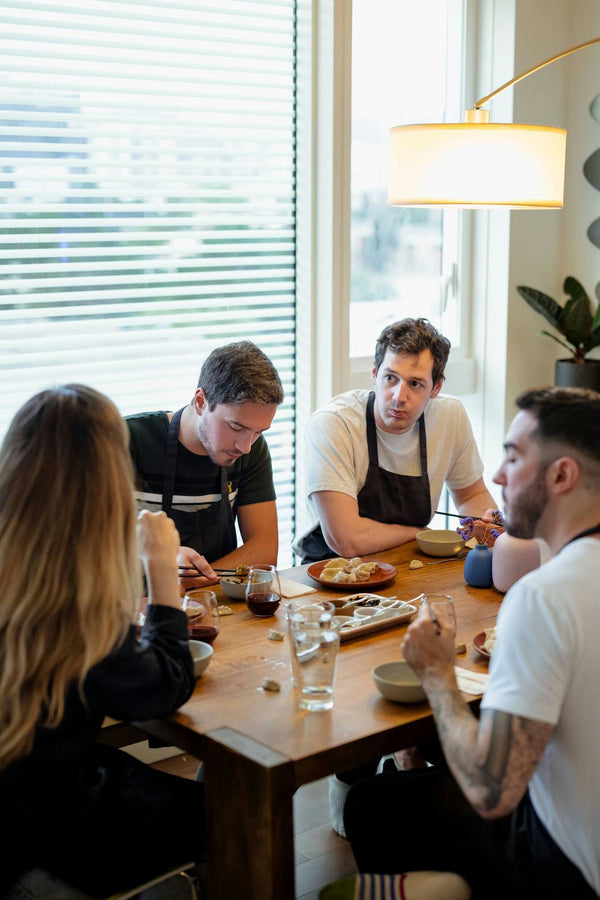 group of four people making dumplings