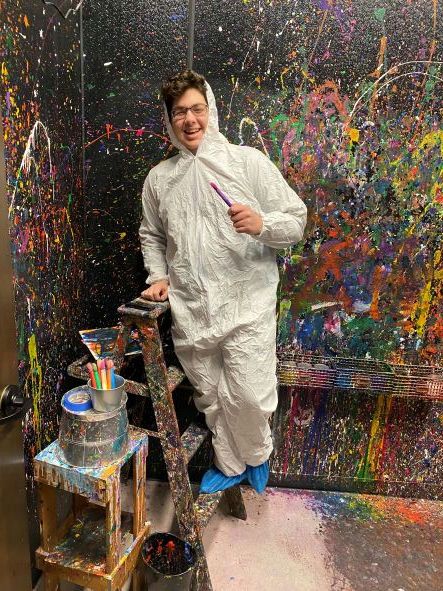 girls laughing in splatter paint room