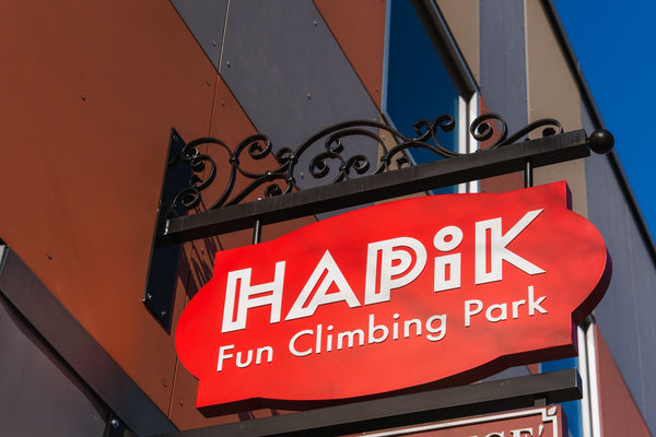 child getting harnessed before climbing