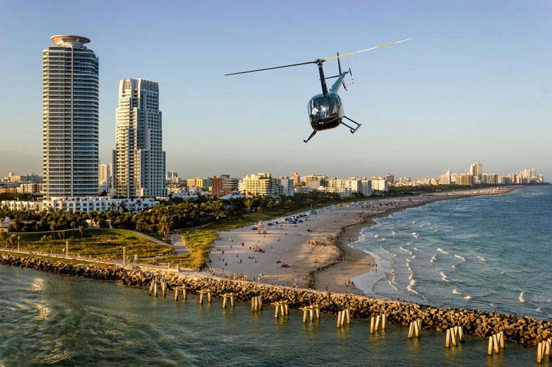 helicopter over beach at sunset