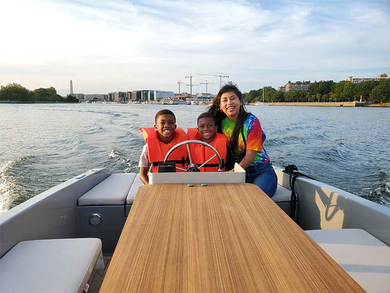 kids-and-adult-steering-boat