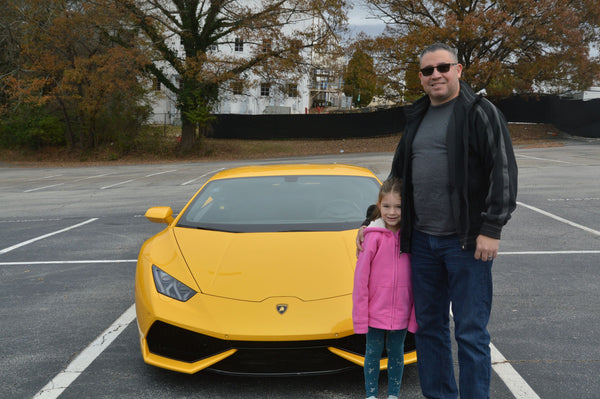 man and daughter by yellow super car