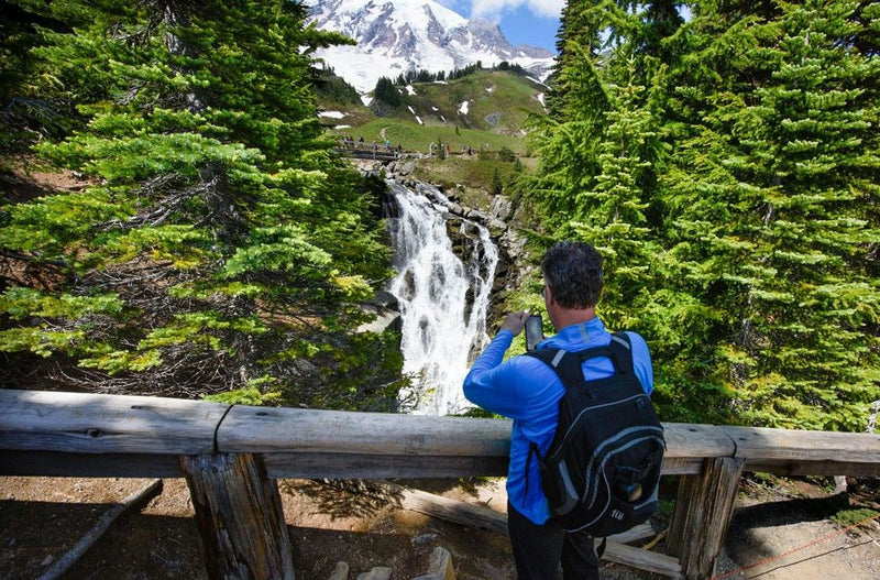 man-taking-photo-of-waterfall