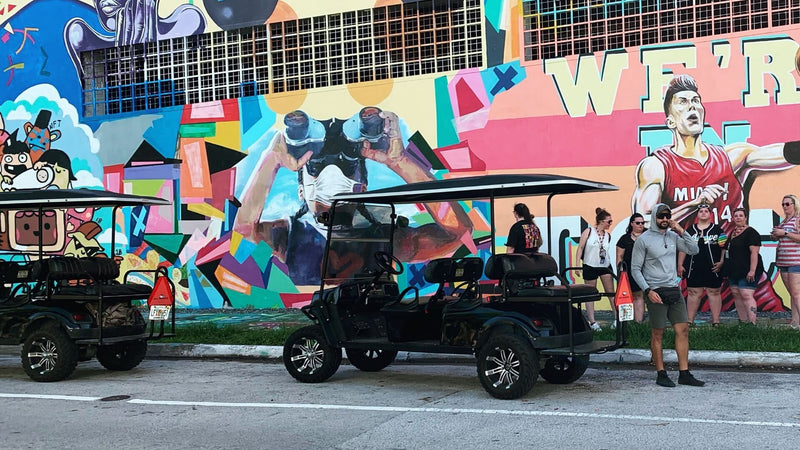 one-golf-cart-in-front-of-mural-of-person-with-binoculars