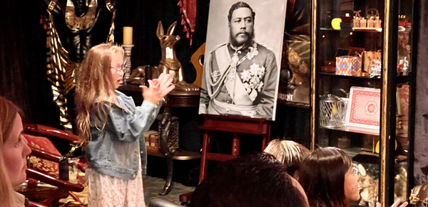 The Magical Mystery Show! At Hilton Waikiki Beach Hotel holding a glass.png