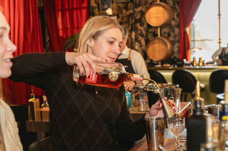 woman pouring red cocktail