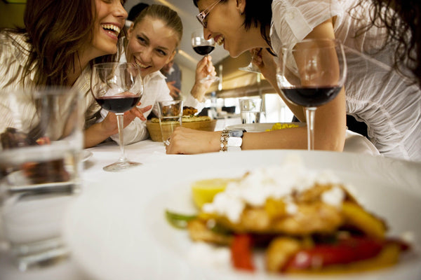 women laughing with rose wine