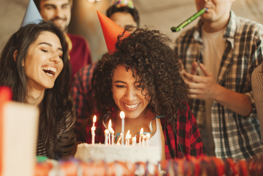 women blowing out candles of her birthday cake