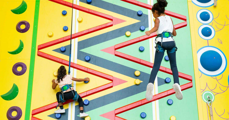2 girls on a climbing wall