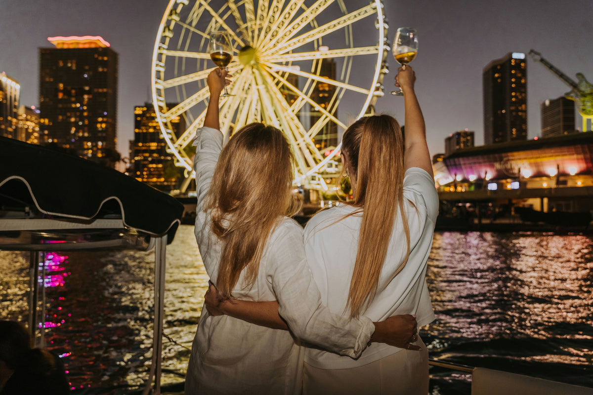 2-women-with-wine-in-front-of-ferris-wheel