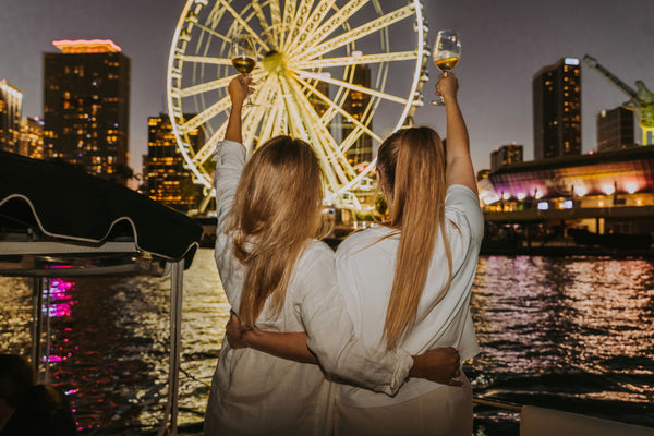 2-women-with-wine-in-front-of-ferris-wheel