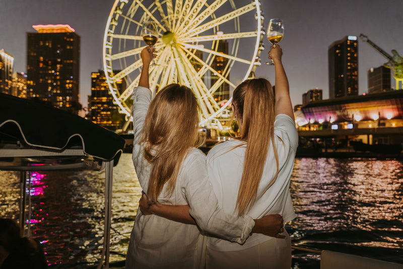 2-women-with-wine-in-front-of-ferris-wheel