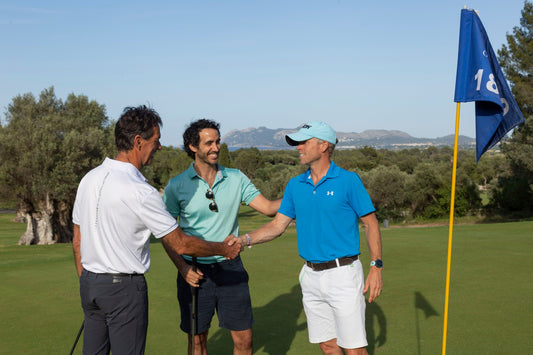 2 men shaking hands on a golf course