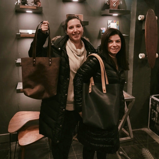 2 women with leather bags