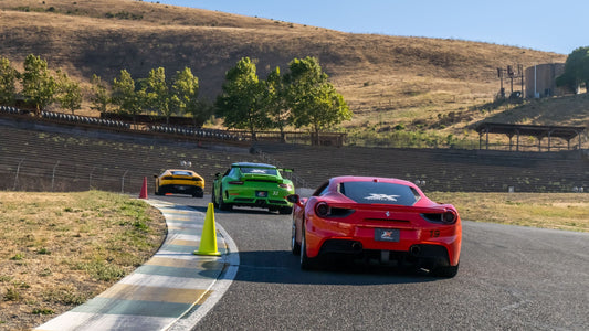 3 luxury cars driving on a racetrack