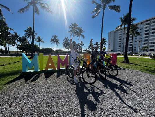 3 people waving on bikes in miami