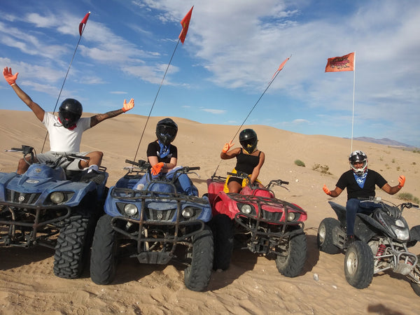 4 people riding ATVs in desert