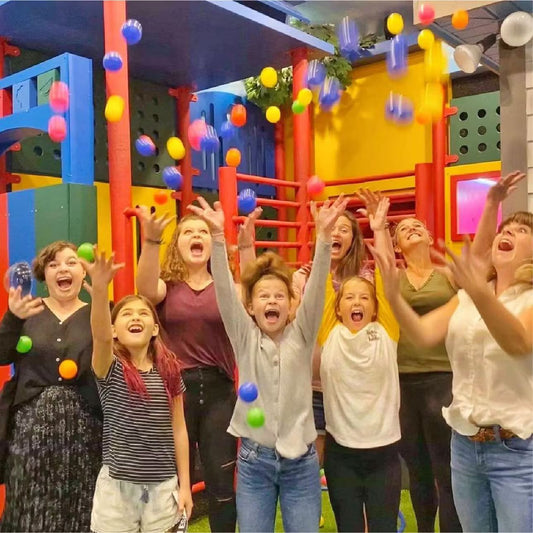 Children enthusiastically throwing balls at the playground escape room