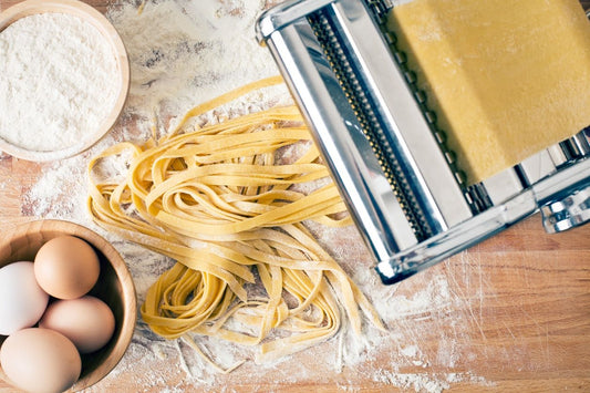 Fresh pasta in flour on table
