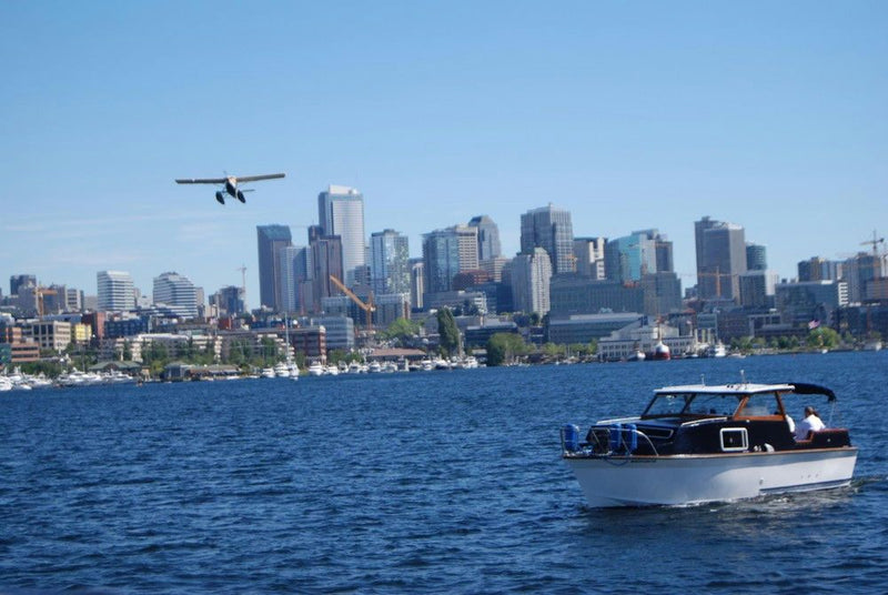 airplane-flying-over-city-with-boat-cruising