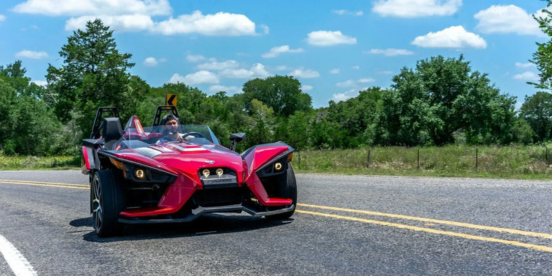 backroads-boogie-1-hour-gps-tour-houston-red-slingshot-curving-tree-lined-backroad.webp