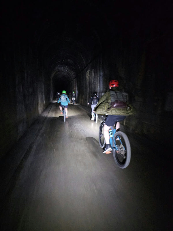 group of bikers in front of tunnel