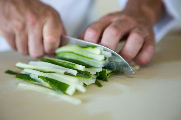 Chopping fresh cucumber into thin strips for sushi.jpg