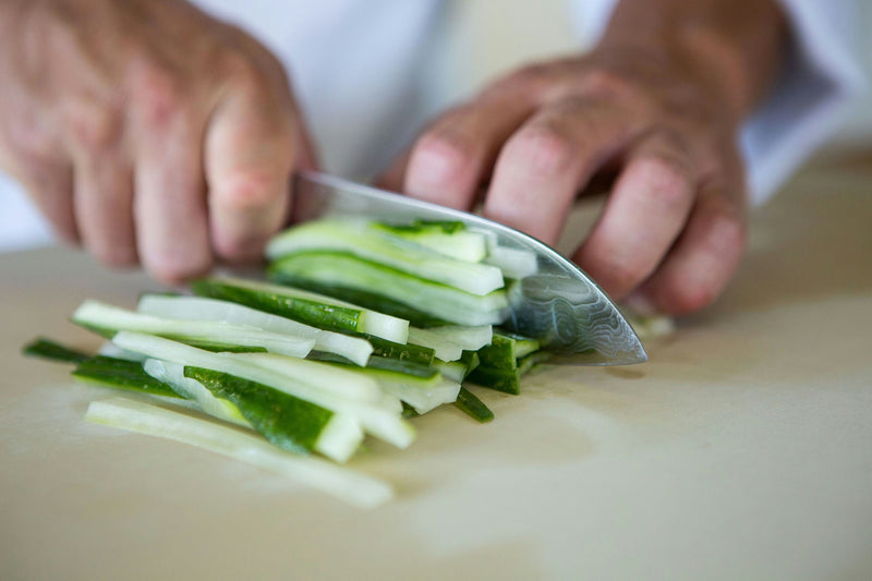 Chopping fresh cucumber into thin strips for sushi.jpg