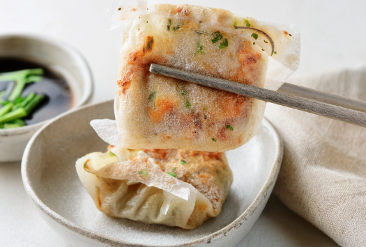 Dumplings on plate with sauce.png