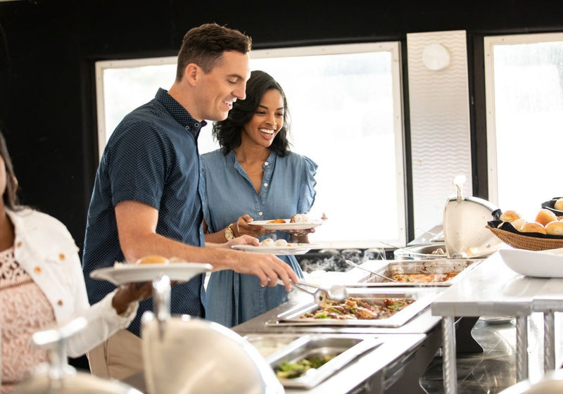 couple loading up their plates at a signature lunch cruise buffet