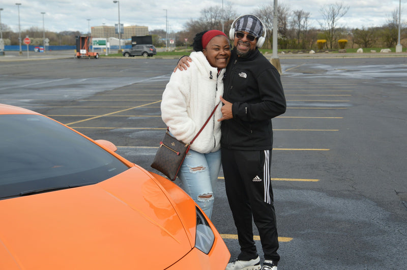 couple with orange super car