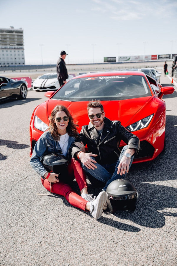couple sitting with red ferrari