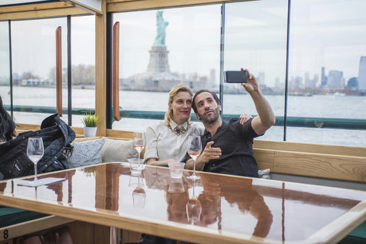 couple taking selfie with statue of liberty.jpeg