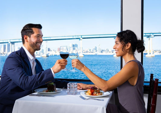 couple toasting in front of the window on san diego premier dinner cruise