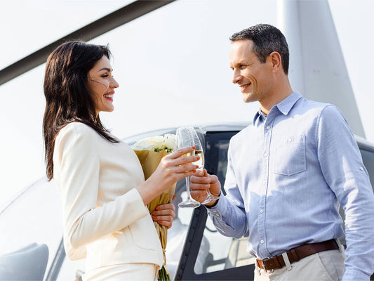 couple with champagne in front of helicopter