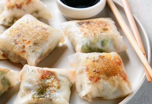 Dumplings on plate with sauce.png