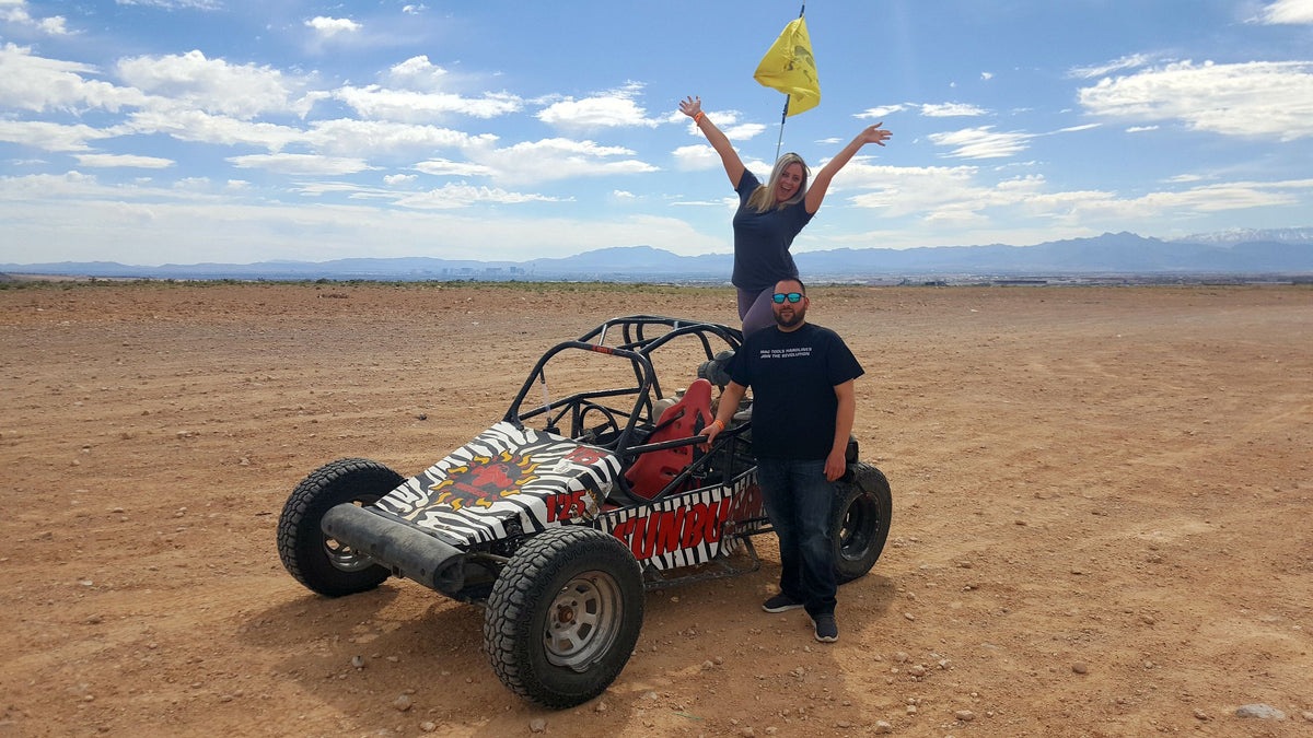 dune-buggy-with-woman-standing-on-and-man-beside