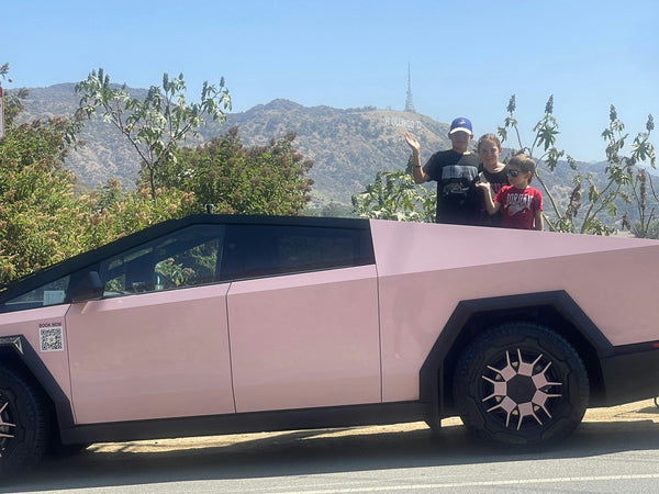 family posing with hollywood sign in cyber truck