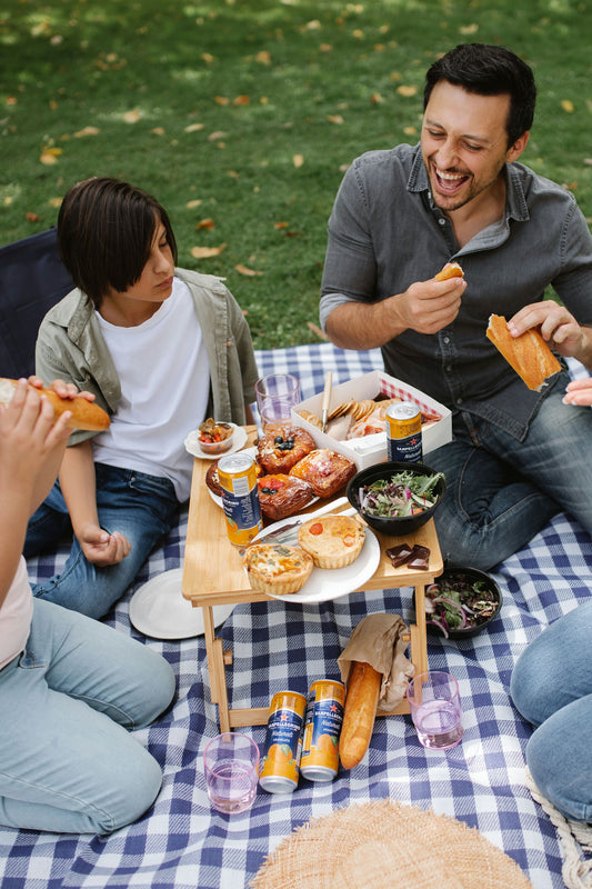 family laughing around picnic spread