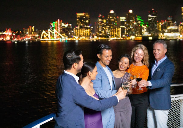 friend toasting with san diego in background at night