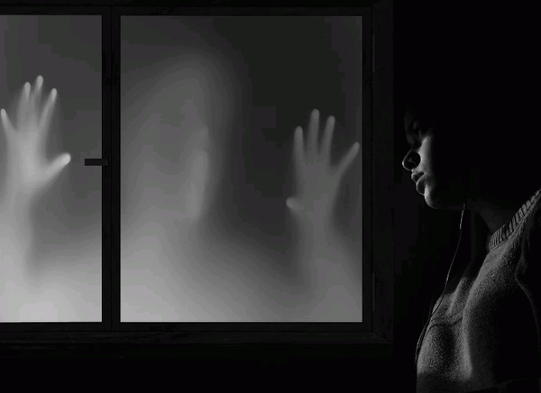 ghost hands on window with man looking