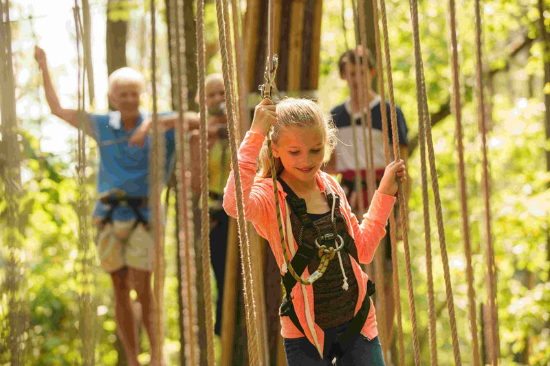 girl-going-through-a-ropes-course-with-her-family