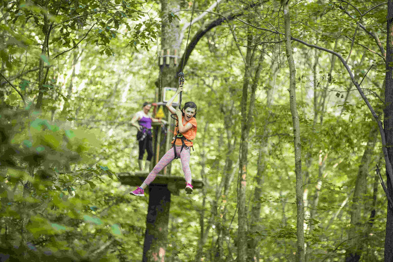 girl-in-orange-shirt-on-a-zip-line