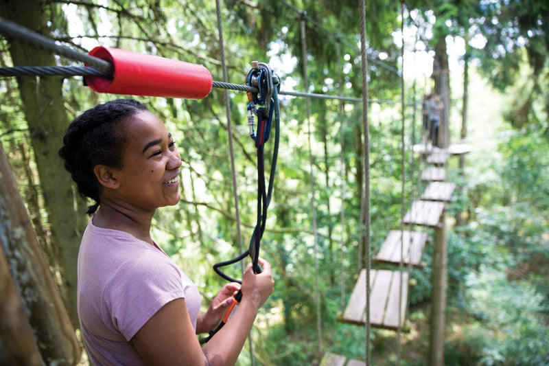 girl-in-purple-getting-read-to-close-a-wood-bridge-at-a-ropes-course