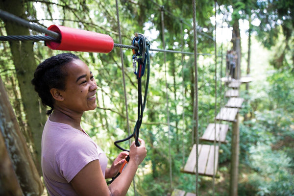 mother helping toddler on ropes course