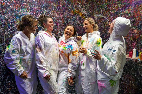 girls laughing in splatter paint room