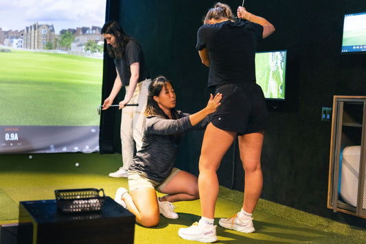 woman taking golf lesson
