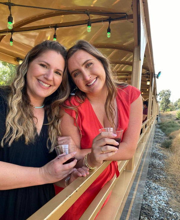 Smiling Woman with Wine Glasses on Train Outing